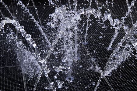 fountain close-up water droplets dark backgroundの写真素材