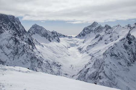 Snowy Mountains peaks in the clouds blue sky Caucasusの写真素材
