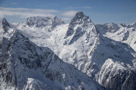 Snowy Mountains peaks in the clouds blue sky Caucasusの写真素材