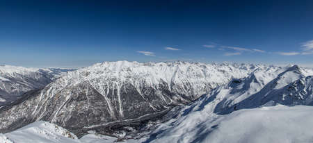Panoramic view of snowy mountains peaks in the clouds blue sky Caucasusの写真素材