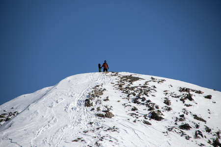 man with snowboard at the top of the snowy Caucasian mountainの写真素材