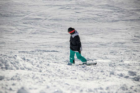 girl on a snowboard rides down the side of the mountainの写真素材