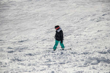 girl on a snowboard rides down the side of the mountainの写真素材