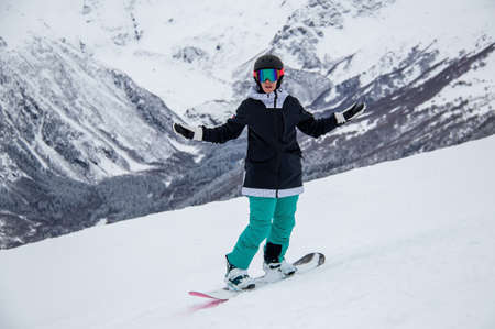 girl on a snowboard rides down the side of the mountainの写真素材