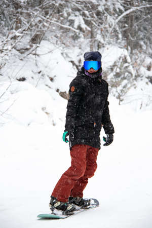girl on a snowboard rides down the side of the mountainの写真素材