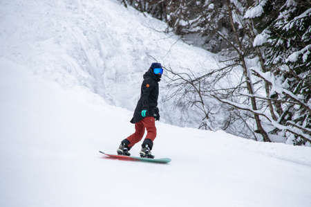 girl on a snowboard rides down the side of the mountainの写真素材