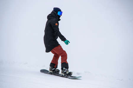 girl on a snowboard rides down the side of the mountainの写真素材