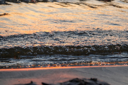 orange sunset over the bay with small waveの写真素材