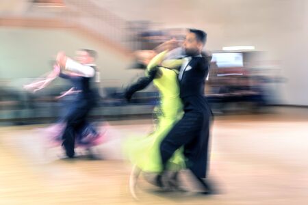 Two blurry dancing couples in the ballroomの写真素材
