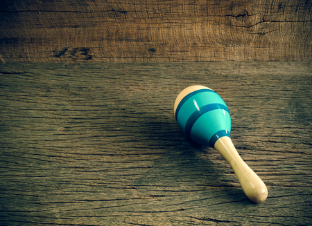 Wooden maraca painted with blue color on the table with copy space (vintage tone)
