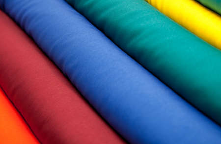 Tubes of colorful plain cotton textiles next to each other, creating a pattern of diagonal lines 