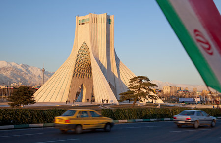 Cars in the street, Azadi Monument, Milad Tower and Iran flag, all in a single frame representing city of Tehran のeditorial素材