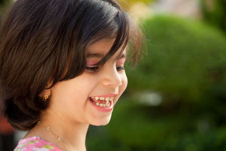 Portrait of a 4 year old laughing Caucasian girl with dark brown hair 