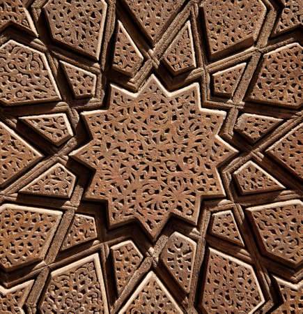Islamic Persian design consisting stars and flowers, carved on the surface of an old wooden door.の写真素材