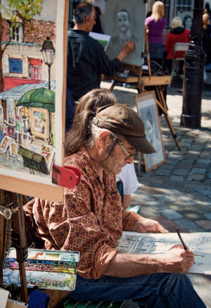 PARIS, FRANCE - JUNE 07, 2010: Artist at Work in Place du Tertre of Montmartre, which is a cafe-lined cobbled square and a hangout for buskers and artists painting landscapes and tourist portraits.のeditorial素材