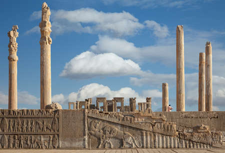 Ruins of Apadana and Tachara Palace behind stairway with bas relief carvings in Persepolis against cloudy blue sky in Shiraz city of Iran.の写真素材