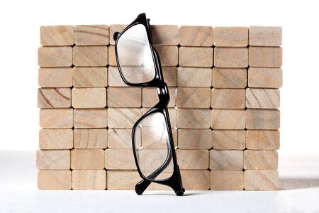 wooden blocks wall with a pair of reading glassesの写真素材