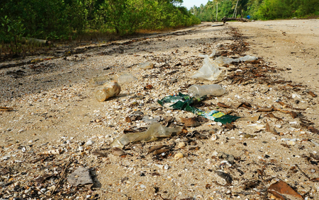 plastic wastes polluted sand beach at coastの写真素材