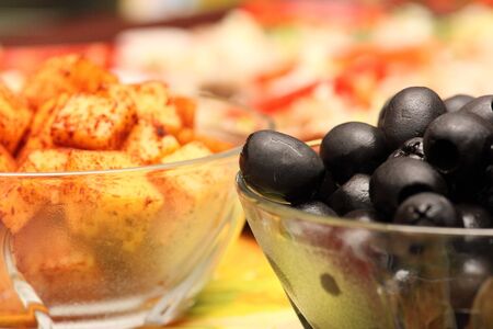 Close up of two small bowls with black olives and cheeseの写真素材