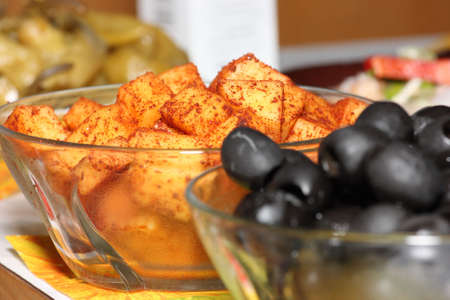 Close up of two small bowls with black olives and cheese