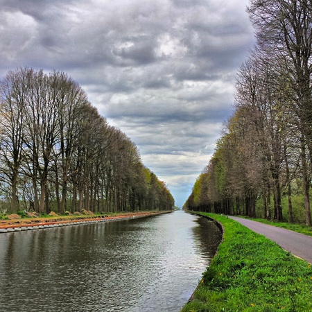 Dramatic sky over a rural landscape with a canal.の素材