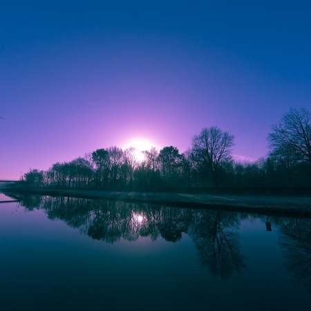 Colorful sky at sunrise reflected in the water of the riverの写真素材