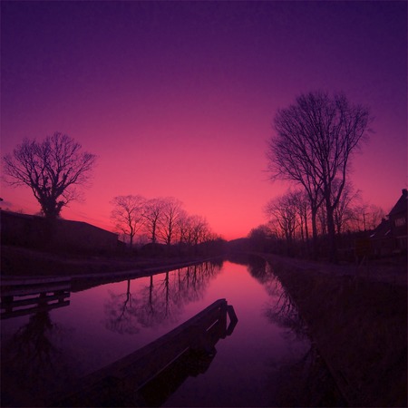 Colorful sky at sunrise reflected in the water of the riverの写真素材