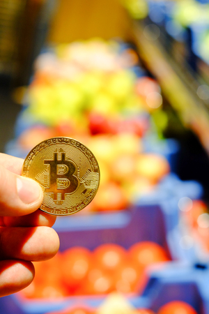 Bitcoin payment for food, fruit and vegetable in a grocery store using cryptocurrency in real life conceptの写真素材