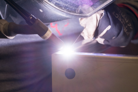 Professional welder in his industrial workshop welding metalの写真素材