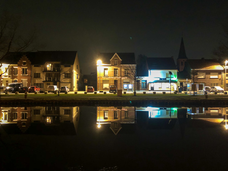 Colorful reflections of the lights of a village at night in the waterの写真素材
