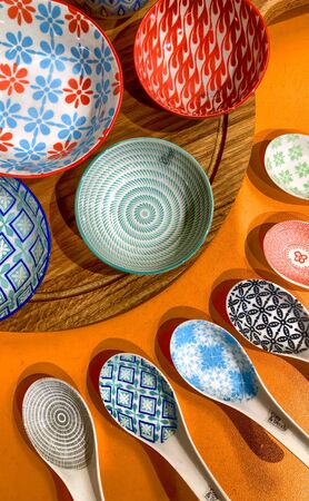 Overhead flat lay shot of contemporary colorful cutlery and ceramic plates in a tabletop setting for a wedding or celebrationの写真素材