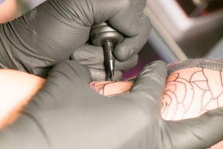 Antwerp, Belgium august 2017, A male tattoo artist making tattoo inside ink studio on blond womanのeditorial素材