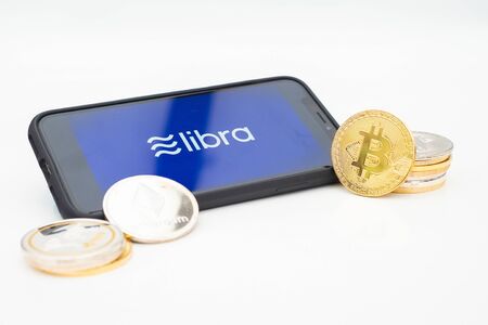 The new currency Lybra from Facebook on a smartphone depicted with some of the current cryptocurrenciesの写真素材