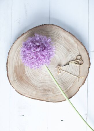 Purple flower and gold scissors laying on a wooden backgroundの写真素材