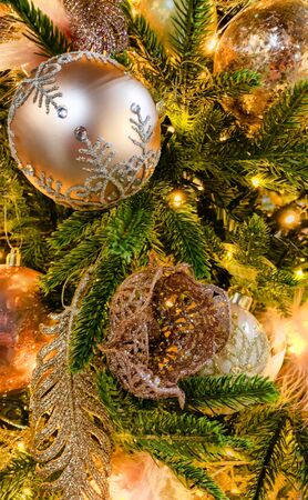 Close up of beautifully decorated Christmas ornament decorations in a Christmas tree with golden and...
