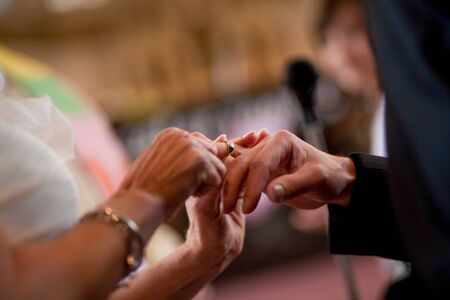 An unrecognizable bride and groom exchanging of the Wedding Rings in church during the christian wedding ceremony の写真素材