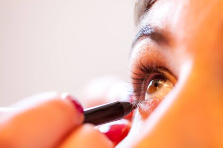 Close up of Applying Eyeshadow makeup for eyes on a womans face showing the concept of beautyの写真素材