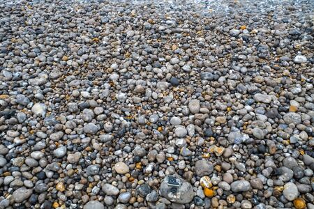 Close up of the pebbles on a beach in Normandy France, creating an Abstract smooth round pebbles sea...