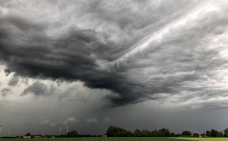 Threatening dark rainy clouds are covering a rural landscape, showing the Overcast and gloomy sky...