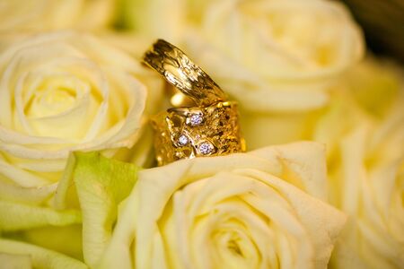 Close-up of two Wedding rings and the wedding bouquet of white on a weddings dayの写真素材