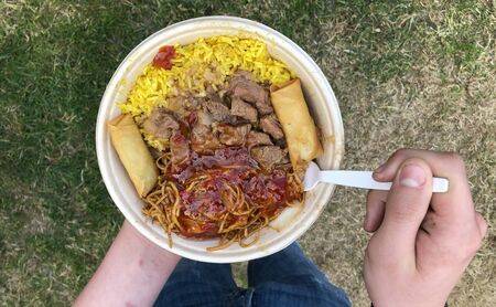 Street Food, Asian specialty with rice, noodles, meat, lumpia and other toppings from a festival...
