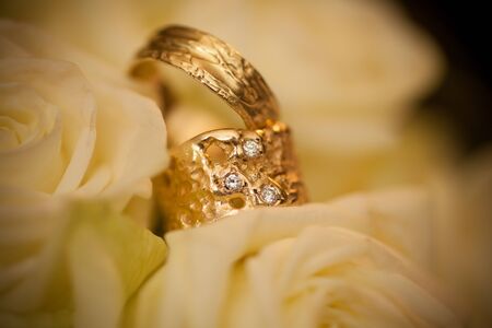 Close-up of two Wedding rings and the wedding bouquet of white on a weddings dayの写真素材