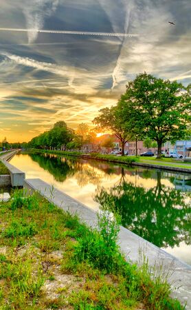 Dramatic sunset over a body of water surrounded by trees. High quality photoの写真素材