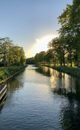 Dramatic sunset over a body of water surrounded by trees. High quality photoの写真素材