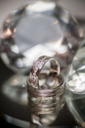 Wedding rings on diamond shaped glass background. High quality photoの写真素材