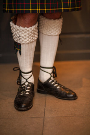 Feet and legs in Scottish skirts, a Scottish traditionally dressed bagpiper plays on St. Patricks Day, holiday costumes for men. High quality photoの写真素材