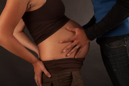 Hands and Belly - Pregnant woman belly holding hands of mother, father and child. High quality photoの写真素材