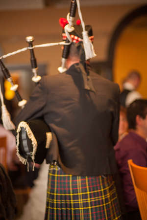 Scottish traditionally dressed bagpiper plays on St. Patricks Day, holiday costumes for men. High quality photoのeditorial素材