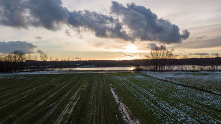 Aerial view of a beautiful and dramatic sunset over a forest lake reflected in the water, landscape drone shot. Blakheide, Beerse, Belgium. High quality photoの写真素材