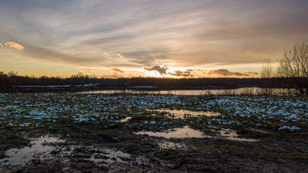 Aerial view of a beautiful and dramatic sunset over a forest lake reflected in the water, landscape drone shot. Blakheide, Beerse, Belgium. High quality photoの写真素材